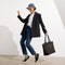 An alternate view of a model holding The Lightweight Zip Tote in Night Song.