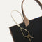 Close up of the handles and key leash detail of The Lightweight Tote in Black Portobello. 