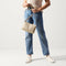 Alternate view of The Casual Crossbody in Parchment, carried by its crossbody strap by a model, shown in motion.