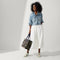 Alternate view of the Classic Tote in Spruce Camo, carried by its top handles by a model, shown from side.