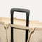 The Zip Travel Tote in  Parchment Basketweave, shown attached to a rolling suitcase using the wrap-around band.