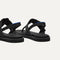 Close up of the heel of The T-Strap Sandal in Black, with Rothy's signature blue halo. 
