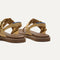 Close up of the heel of The T-Strap Sandal in Metallic Golden Sun, with Rothy's signature blue halo. 