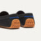 Close up of the heel of The Daily Driver in Black, with raised peg outsoles and Rothy's signature blue halo. 