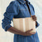 Model shown holding the Convertible Clutch in Oat Latte.