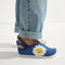 hover | A child wearing The Kids Clog in Indigo Daisy. 