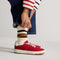 hover | A child modeling The Kids Stretch Sneaker in Firecracker.