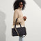 hover | Overlay:: Shown with The Crossbody Strap (sold separately.) | Alt:: The Classic Tote in Luna, worn over the shoulder by a model, shown from the side.