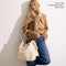 The Bucket Bag in White Sand shown on model. 