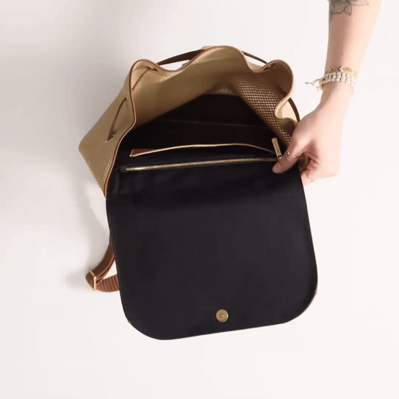 Animated GIF showing a model packing The Cinch Backpack with items.