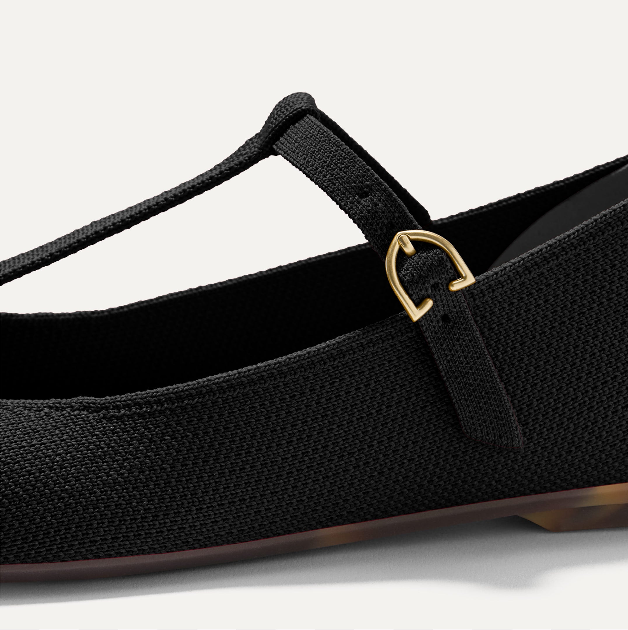 Close up of the T-shaped strap and adjustable buckle of The T-Strap Mary Jane. 