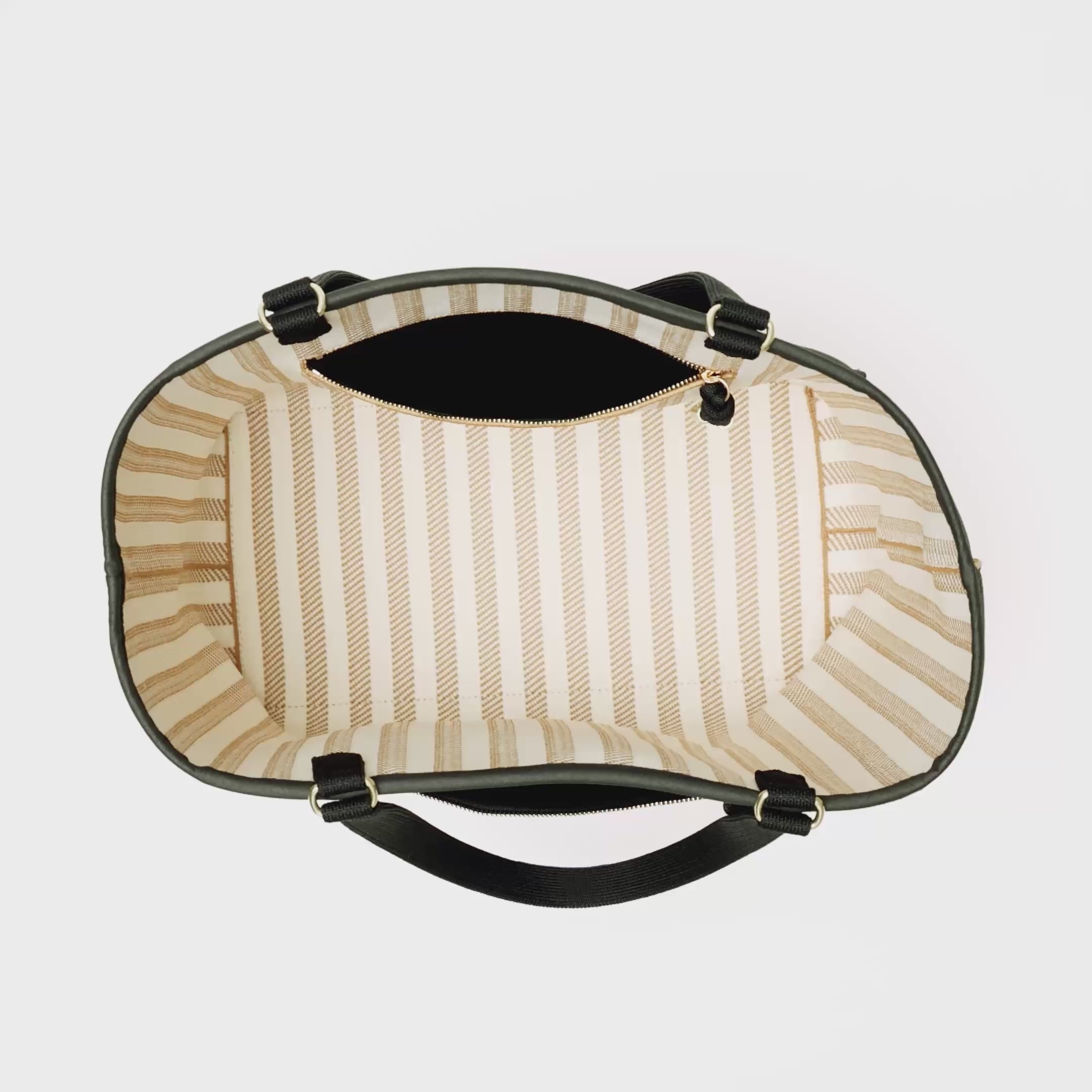 The Two-Way Tote in Sandbar is packed with a laptop, notebook, water bottle, a Petite Pouch and a deck of cards. In the interior pocket, small toiletries and a pair of sunglasses are added, and is then zipped closed. An iPhone is also zipped into the outer pocket. The model ties a scarf around the handle and carries the bag out of frame. 